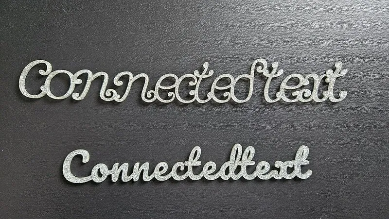 Texto conectado cortado en acrílico silver glitter montado sobre contrachapado negro